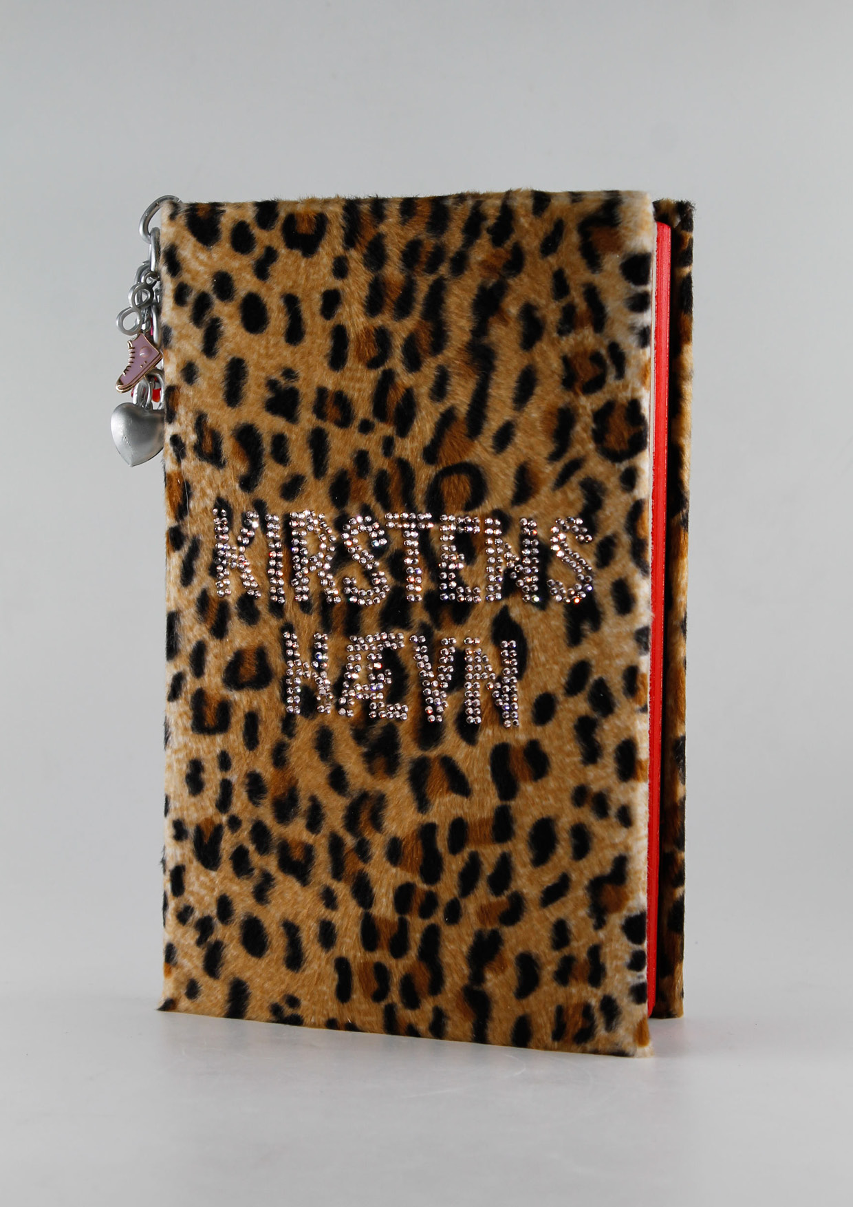 A book covered in leopardcoloured velour and the words Kirstens Hævn in rhinestones.