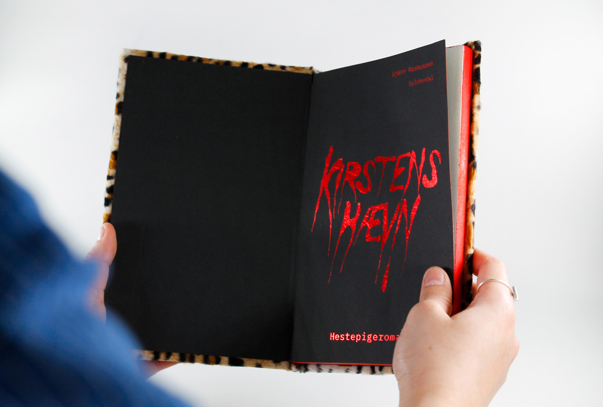 Open book with black page and red illustrative typography.