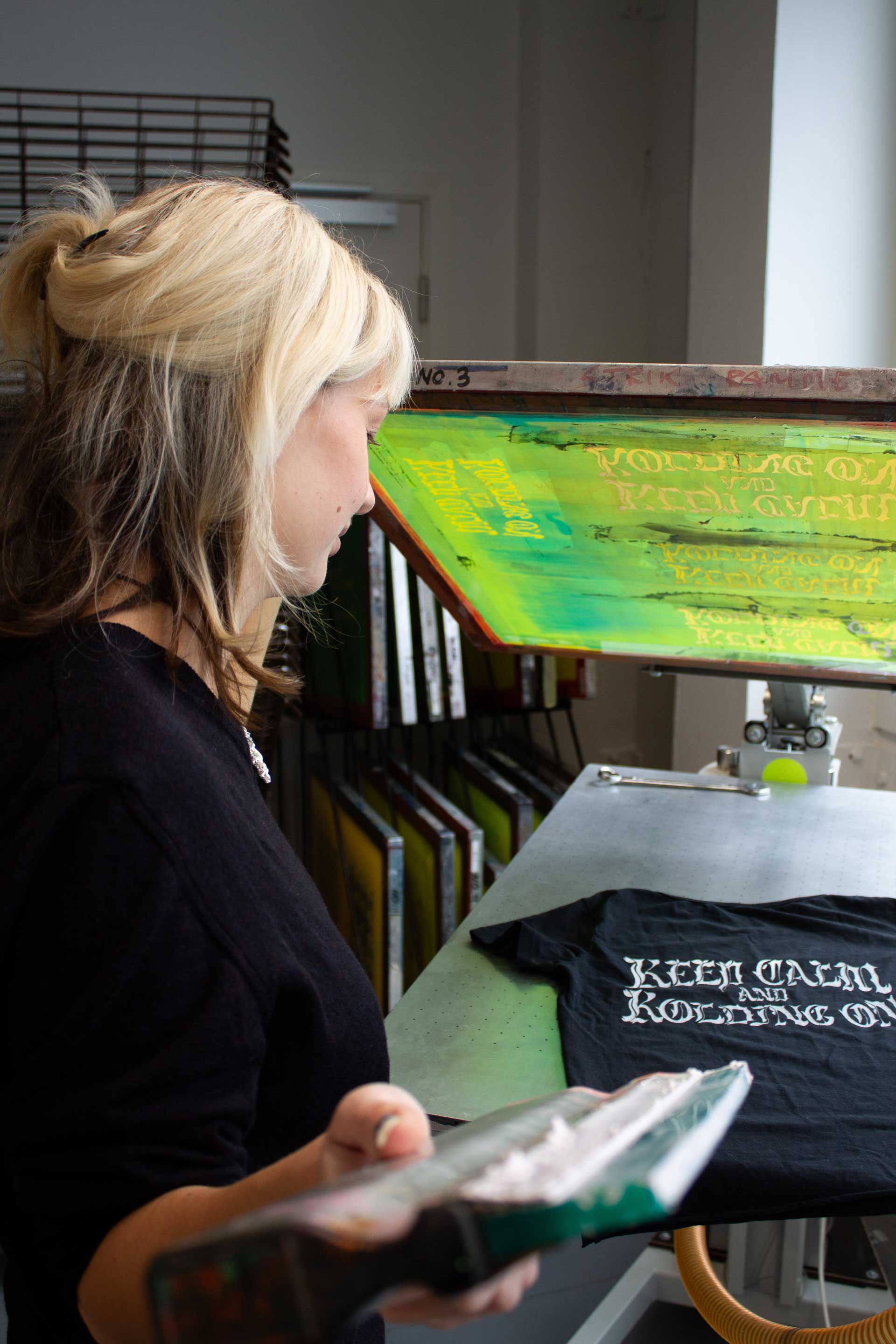 A picture of Cecilia Brandt silk screen printing a t-shirt.